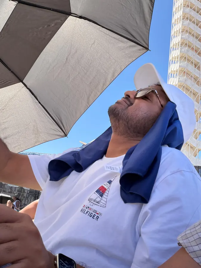 Amogh tilting his head back under an umbrella at Circuit of the Americas