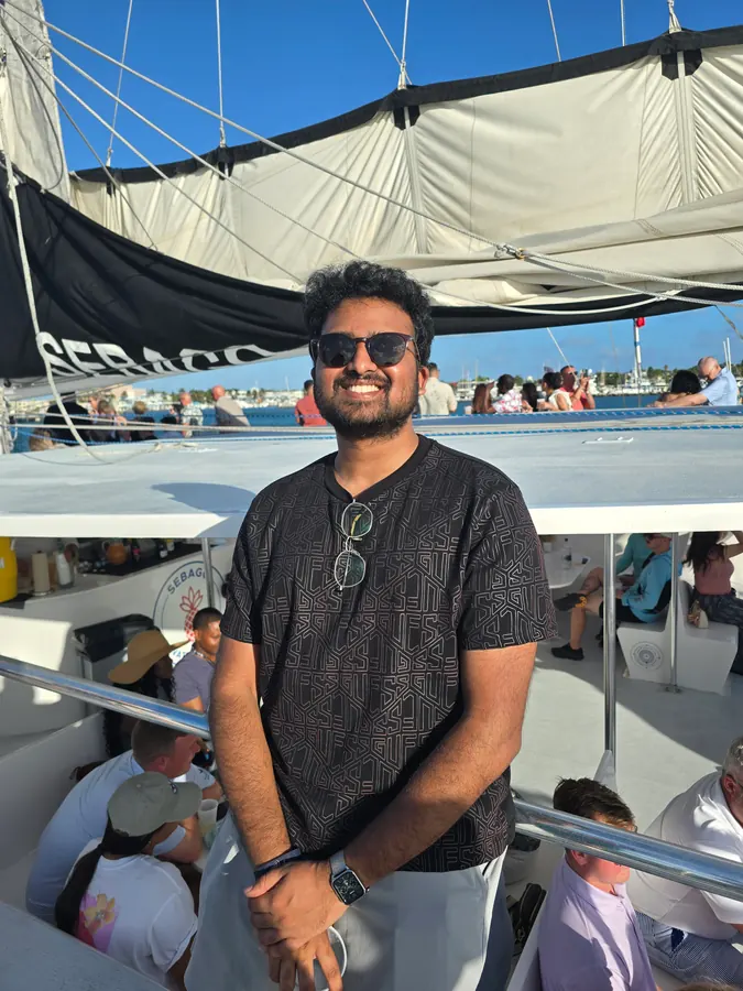 Amogh smiling on the deck of a sunset cruise
